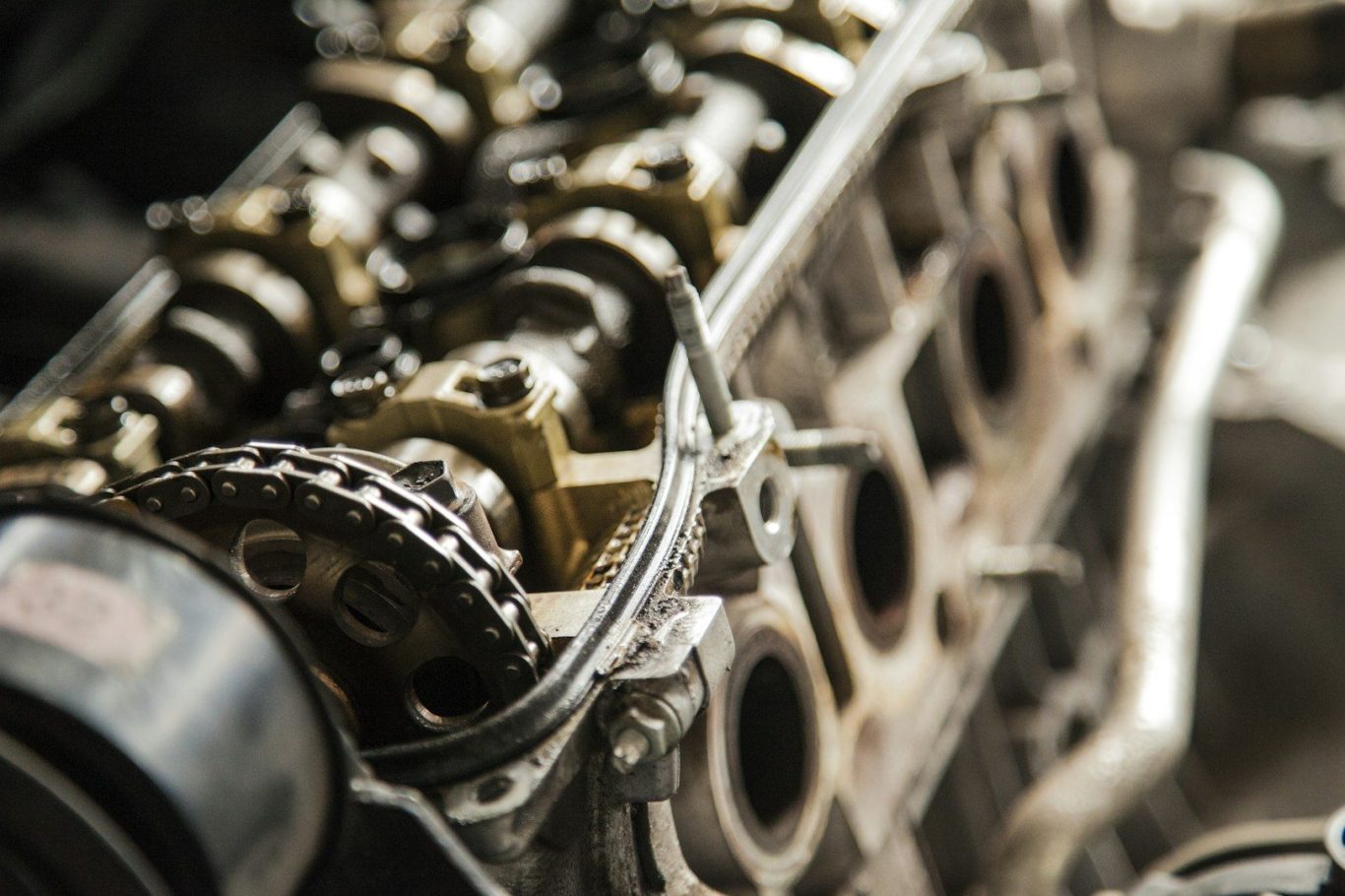 Motorblock mit Zahnrad- und Kettenantrieb, leicht verwittert und ölig.
